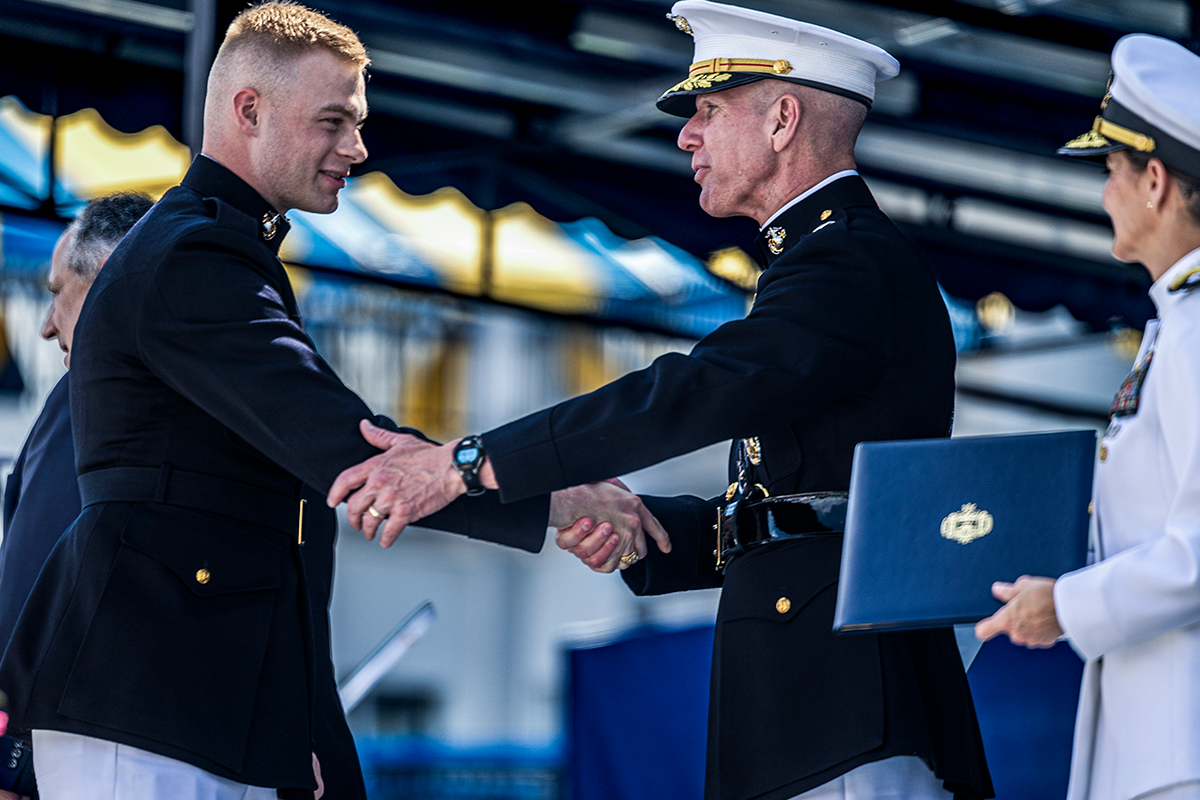 Senior officer congratulates newly commissioned officer during commissioning ceremony following Officer Candidates School.