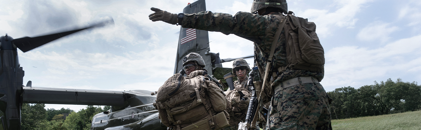 Marine officers in tactical gear directing helicopter landing operations during The Basic School leadership training exercise.