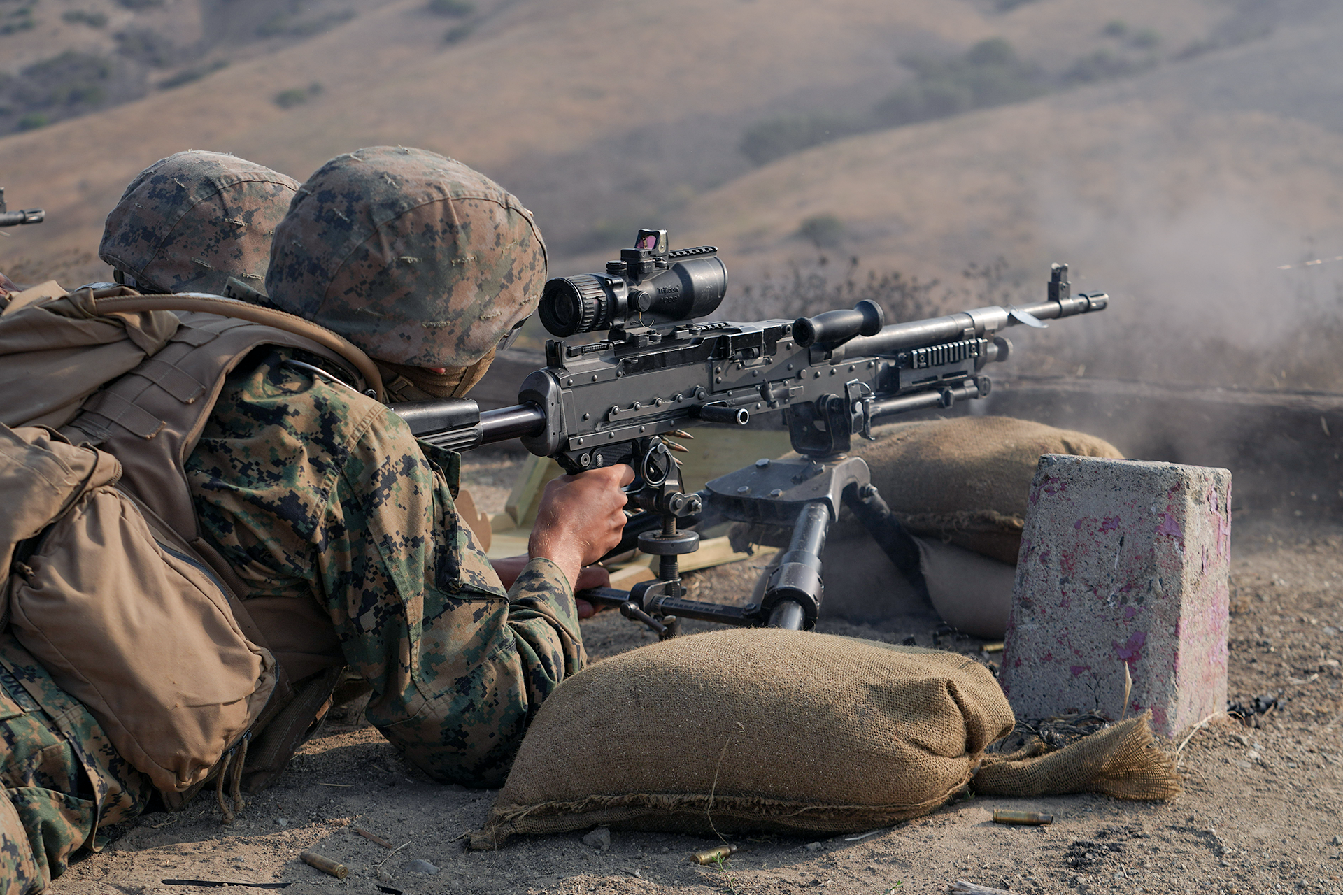 Marines operate M240 medium machine gun with optic mounted on tripod during live fire training at Camp Pendleton.