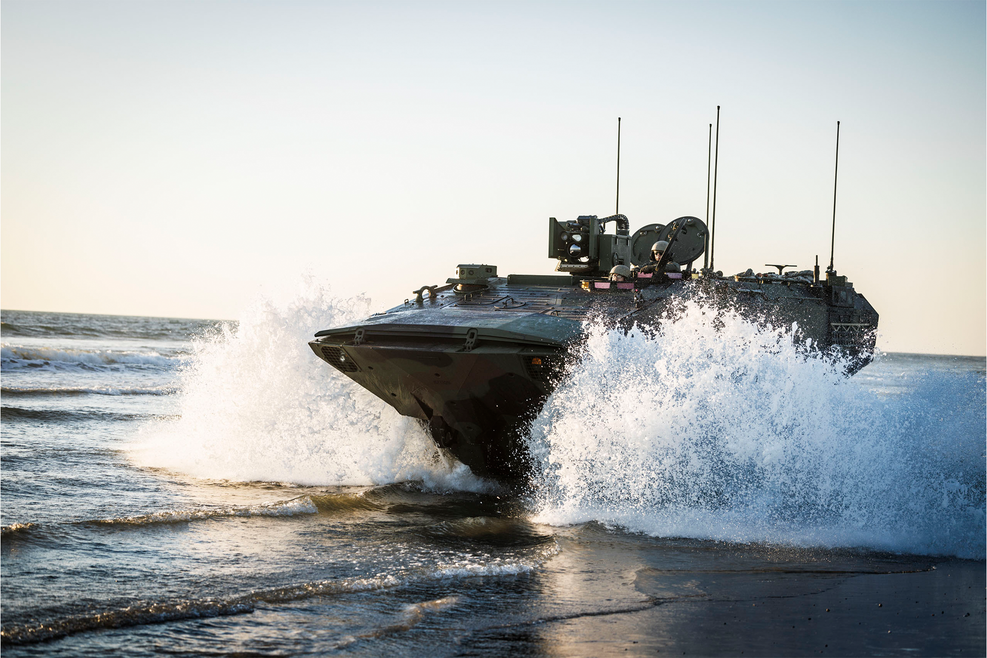 Amphibious Combat Vehicle drives through surf with turret and antennas during water operations at Camp Pendleton.