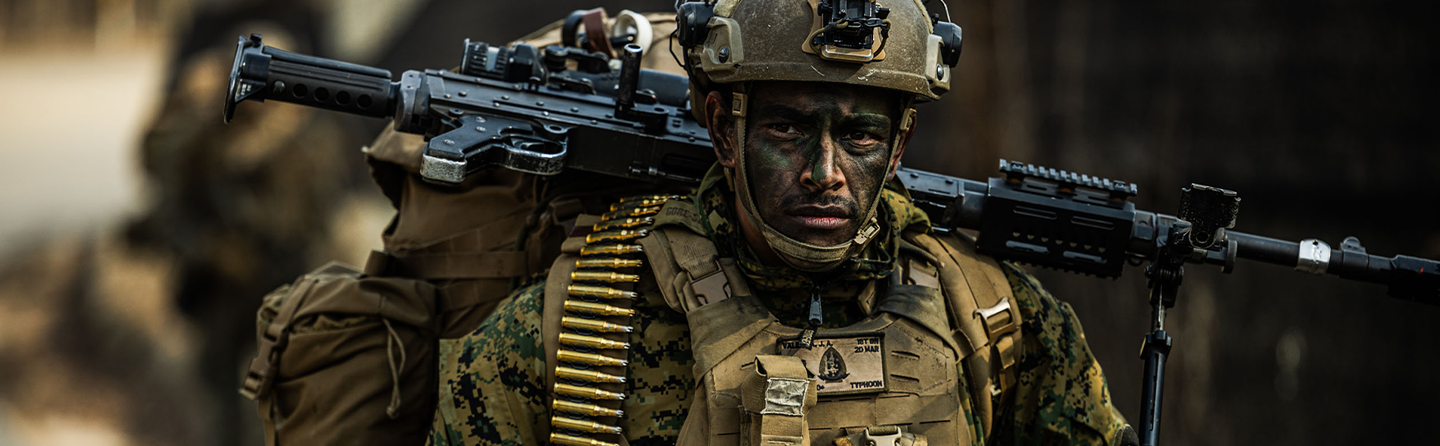 Marine machine gunner carries M240 with ammunition belt during force-on-force training exercise in South Korea.