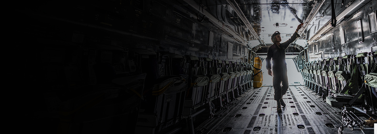 A helicopter maintenance Marine walks through the fuselage of a CH-53K King Stallion helicopter. 
